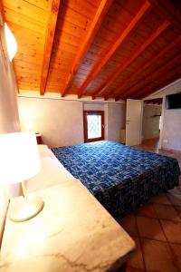 ein großes Bett in einem Zimmer mit Holzdecke in der Unterkunft Affittacamere Residenza Del Duca in Solferino
