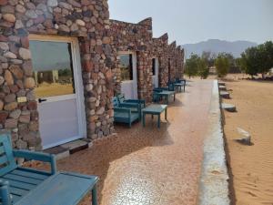 a row of benches sitting outside of a stone building at Musa Camp in Nuweiba