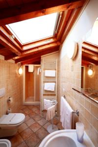 a bathroom with a toilet and a sink and a skylight at Affittacamere Residenza Del Duca in Solferino