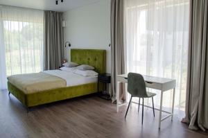 a bedroom with a bed and a desk and window at SeaFly in Palanga
