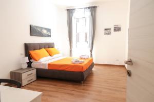 sypialnia z łóżkiem z pomarańczowymi i żółtymi poduszkami w obiekcie Trastevere Magic House Luxury Suite w Rzymie