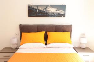 1 dormitorio con 1 cama con 2 almohadas amarillas en Trastevere Magic House Luxury Suite, en Roma