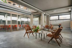 a large room with chairs and tables in a room with windows at 'RE-Dama Hostel in Florence