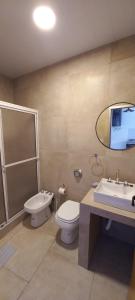 a bathroom with a toilet and a sink and a mirror at EL CARMEL in Paraná +52 photos