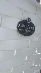 een bord voor een grijs huis rood en open haard bij Grey House Bed & Breakfast in Latina