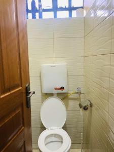 a bathroom with a white toilet in a stall at Kiths Place 2 (One Bedroom House) in Nairobi