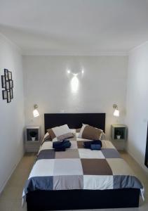 um quarto com uma cama grande e almofadas azuis em LEON DEL SUR em San Miguel de Abona