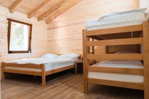 a bedroom with two bunk beds in a wooden cabin at Vucja Gora in Foča