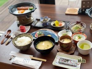 a table topped with bowls and plates of food at 湯布院 旅館 やまなみ Ryokan YAMANAMI in Yufuin