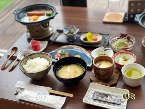 una mesa cubierta con tazones y platos de comida en 湯布院 旅館 やまなみ Ryokan YAMANAMI, en Yufu