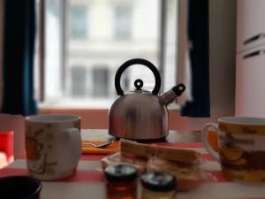 a tea kettle sitting on a kitchen counter with two cups at Centralissimo grazioso monolocale in Turin