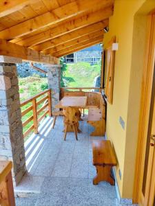 a patio with a table and a bench on a porch at Bella Italia chalet in Massino Visconti