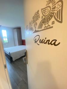 Zimmer mit einem Bett und einer Tür mit Logo in der Unterkunft VILLA FENIX OSIO SOTTO 2 in Osio Sotto