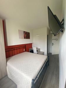 1 dormitorio con 1 cama y TV en la pared en VILLA FENIX OSIO SOTTO 2, en Osio Sotto