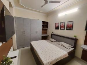 um quarto com uma cama e uma televisão de ecrã plano em RJ Homestay em Dehradun