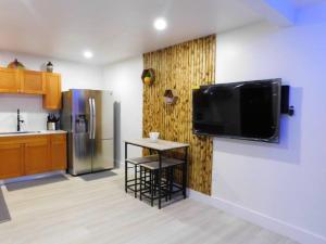 a kitchen with a small table and a television on a wall at cozy apartment, with separate entrance in Miami