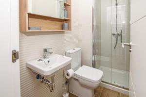 a bathroom with a toilet and a sink and a shower at Nautilus 3 - Elegante Apartamento para 6 con Piscina, Wifi y AC en Rota in Rota