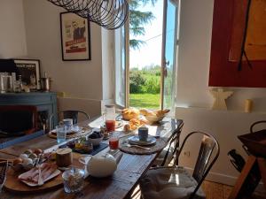 a table with food on it in a room with a window at L' Embellie sur Lot in Sainte-Livrade-sur-Lot