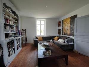 a living room with a couch and a table at L' Embellie sur Lot in Sainte-Livrade-sur-Lot