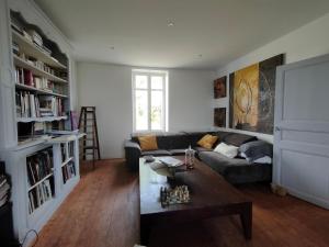 a living room with a couch and a table at L' Embellie sur Lot in Sainte-Livrade-sur-Lot +9 photos