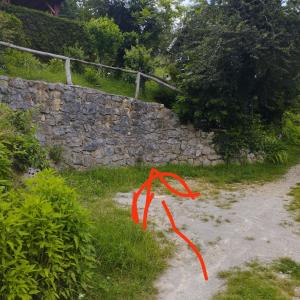 ein rotes Band auf einem Weg neben einer Steinmauer in der Unterkunft Holiday home Mrežnički šum in Generalski Stol