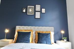 a bedroom with blue walls and a bed with blue pillows at Magnificent One Bed Penthouse in Nottingham