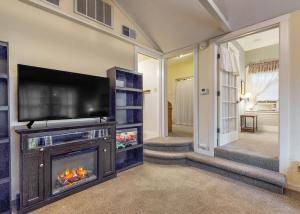 a living room with a fireplace and a flat screen tv at Forbestown Carriage House in Lakeport