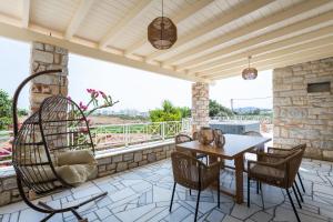 an outdoor patio with a table and chairs and a wooden ceiling at Sun and Salt 3bedroom House in Aliki