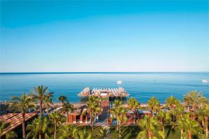 a view of a resort with palm trees and the ocean at Kirman Sidera Luxury & Spa in Okurcalar