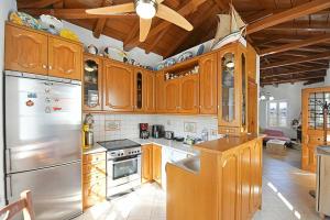 a kitchen with wooden cabinets and stainless steel appliances at Margarita's House in Hydra