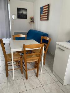 a kitchen with a table and chairs and a couch at Appartement 1 chambre et cuisine VIERVILLE-SUR-MER,plage du Débarquement in Vierville-sur-Mer