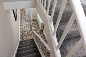 uma escada com piso em azulejo e um corrimão de escadas em Tredenwith House em St Just