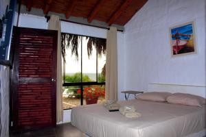 a bedroom with a bed and a large window at Marina Bungalows in Los Órganos