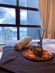 a plate of food on a bed with a window at Modern Suites at Arte Mont Kiara in Kuala Lumpur
