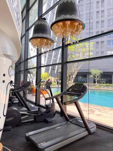a group of treadmills in a gym with large windows at Modern Suites at Arte Mont Kiara in Kuala Lumpur