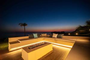 a white couch sitting on a deck at night at Cielo e Mare Villas in Falasarna