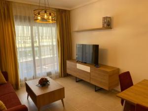 a living room with a flat screen tv and a table at PLAZAMAYOR in Calpe