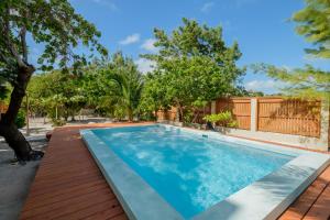 a swimming pool in a backyard with trees at Suite 3 at Island Pearl Gold Standard Certified in Caye Caulker +9 photos