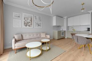un soggiorno con divano e 2 tavoli di Angielska Grobla 5 Apartinfo Apartments a Danzica