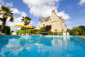 a swimming pool in front of a house at Le Gîte du Château de la Vérie in Challans