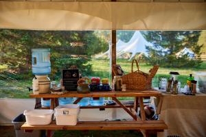 a table in a tent with food on it at Hôtel UNIQ - Domaine Saint-Bernard - Tentes Glamping in Mont-Tremblant
