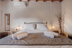 a bedroom with a large bed with two pillows on it at Alice Cottage in Viros Village in Virós