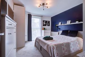 a bedroom with a bed with a blue wall at Pass the Keys Cosy Apartment in the heart of Chelmsford in Chelmsford