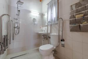 a white bathroom with a toilet and a sink at Alice Cottage in Viros Village in Virós