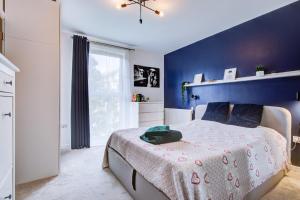 een slaapkamer met een bed met een blauwe muur bij Pass the Keys Cosy Apartment in the heart of Chelmsford in Chelmsford