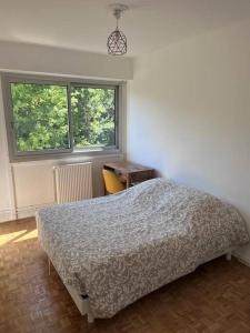 1 dormitorio con cama, escritorio y ventana en Beau Duplex Cenon résidence calme, vue arborée, en Cenon