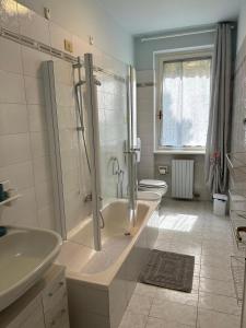 uma casa de banho com uma banheira, um chuveiro e um lavatório. em Sebino Holiday Home em Monte Isola