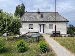 een wit huis met een tafel ervoor bij Česlovos sodyba in Zarasai