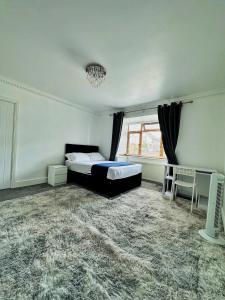 een slaapkamer met een bed en een raam bij Blue rain in Hillingdon