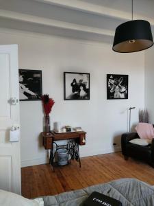 a living room with a table and pictures on the wall at L' Embellie sur Lot in Sainte-Livrade-sur-Lot